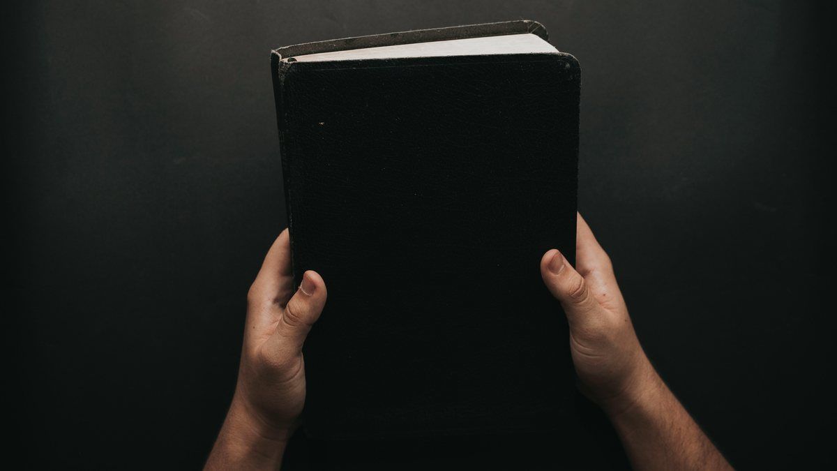 Hands resting on an open Bible