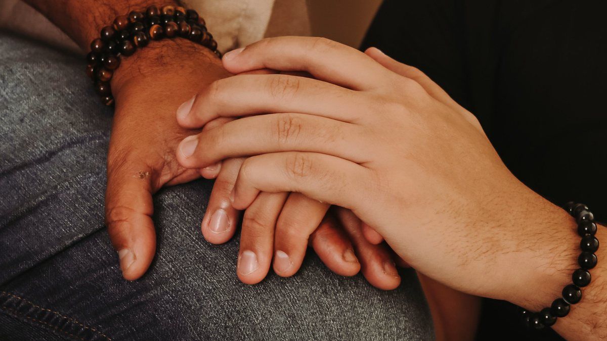 Two people holding hands in support